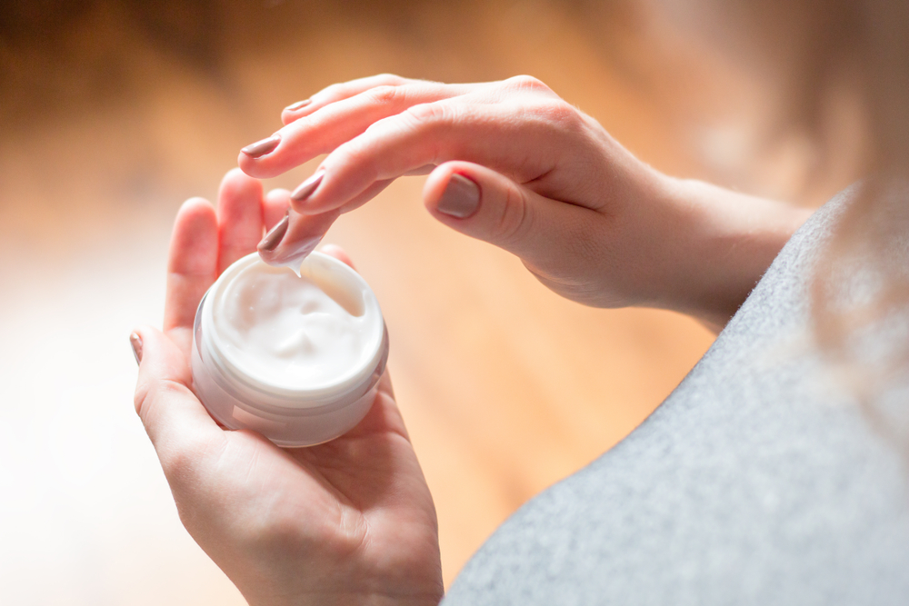 woman's hands applying moisturizer