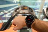 smartwatch on man's arm showing heart rate while on treadmill